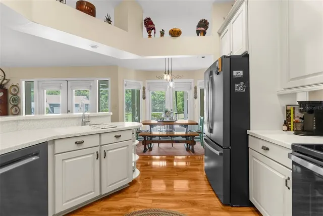 a dining room with furniture a chandelier and wooden floor
