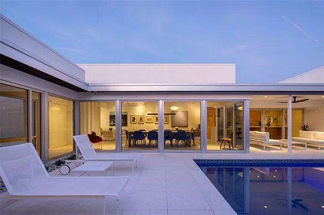 a living room with furniture a flat screen tv and large windows