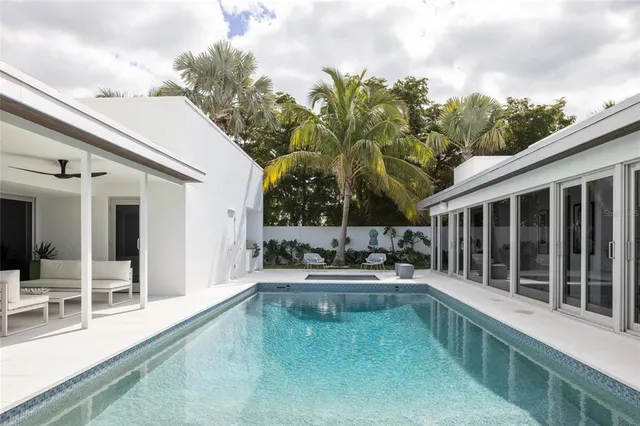 a view of a house with a swimming pool and sitting area