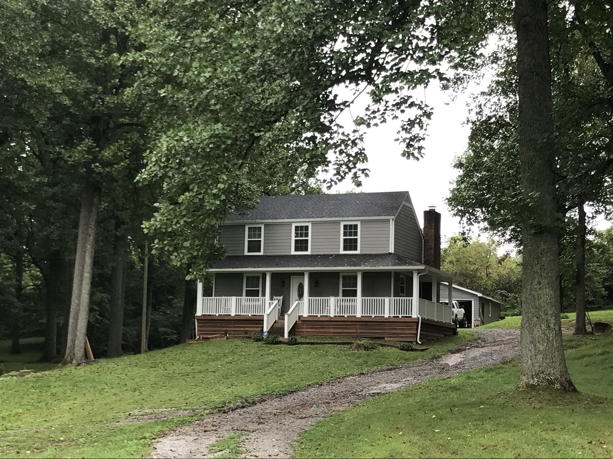 a view of a yard in front of a house with large tree