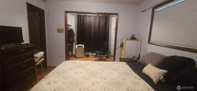 a bed room with a bed a television and a chair