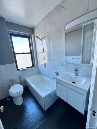 a spacious bathroom with a sink toilet a mirror and window