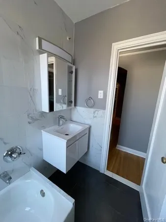 a bathroom with a sink mirror and tub