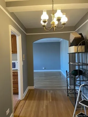 a room with wooden floor and chandelier