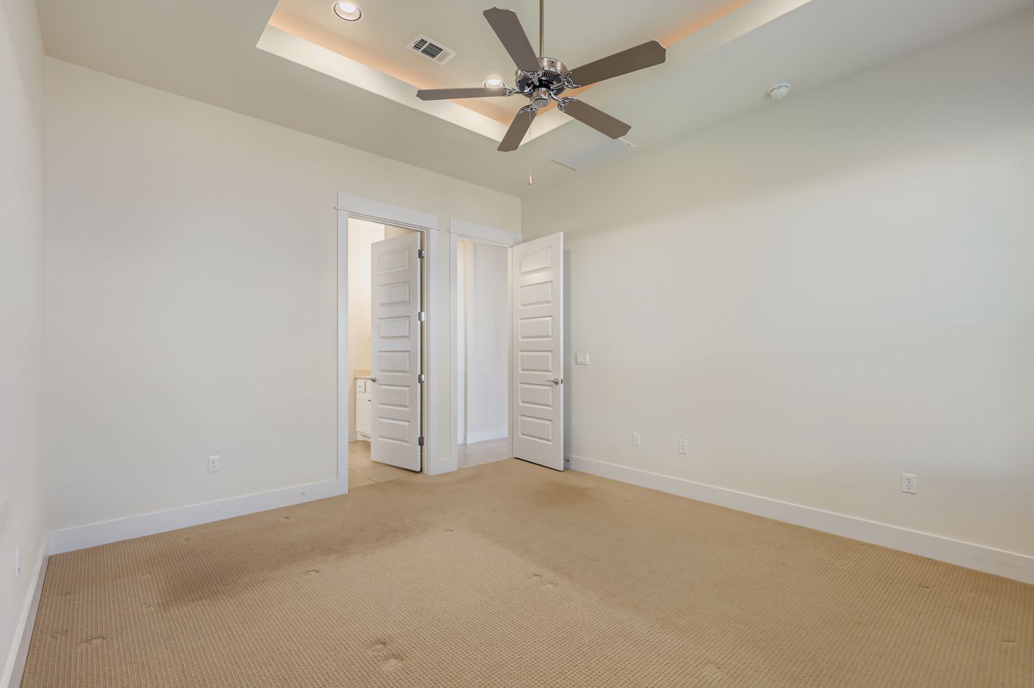 13116 Wingate Way Austin, TX 78727 - Photo 15 of 26 Unfurnished bedroom featuring a raised ceiling, carpet floors, ceiling fan, ensuite bath, and recessed lighting