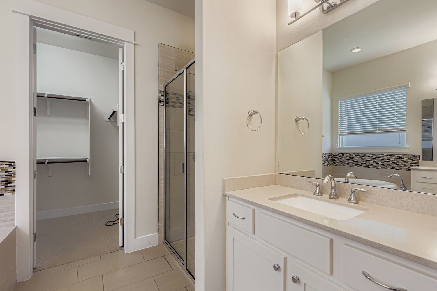 13116 Wingate Way Austin, TX 78727 - Photo 16 of 26 Bathroom featuring vanity, a shower stall, light tile patterned flooring, and a spacious closet
