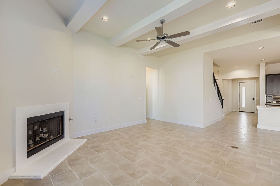 13116 Wingate Way Austin, TX 78727 - Photo 6 of 26 Unfurnished living room with beam ceiling, recessed lighting, a fireplace with raised hearth, and ceiling fan