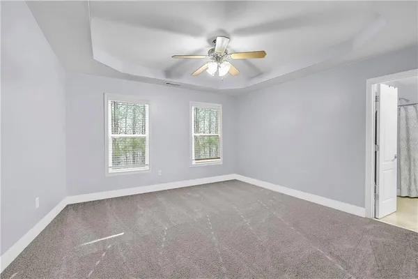 an empty room with windows and fan