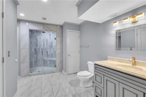 a bathroom with a sink a toilet and shower