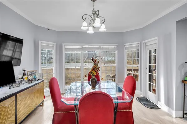 a view of a dining room with furniture a chandelier and wooden floor