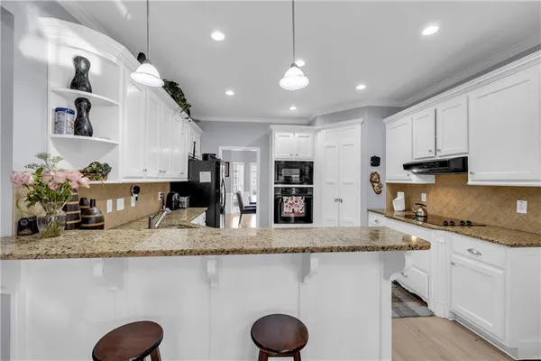 a kitchen with stainless steel appliances granite countertop a sink a stove and a refrigerator