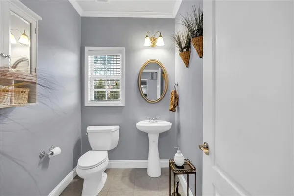 a bathroom with a toilet sink vanity and mirror