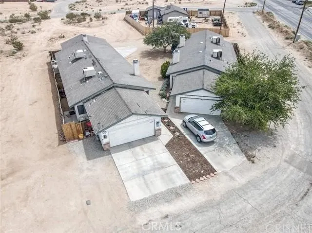 an aerial view of a house with backyard and patio