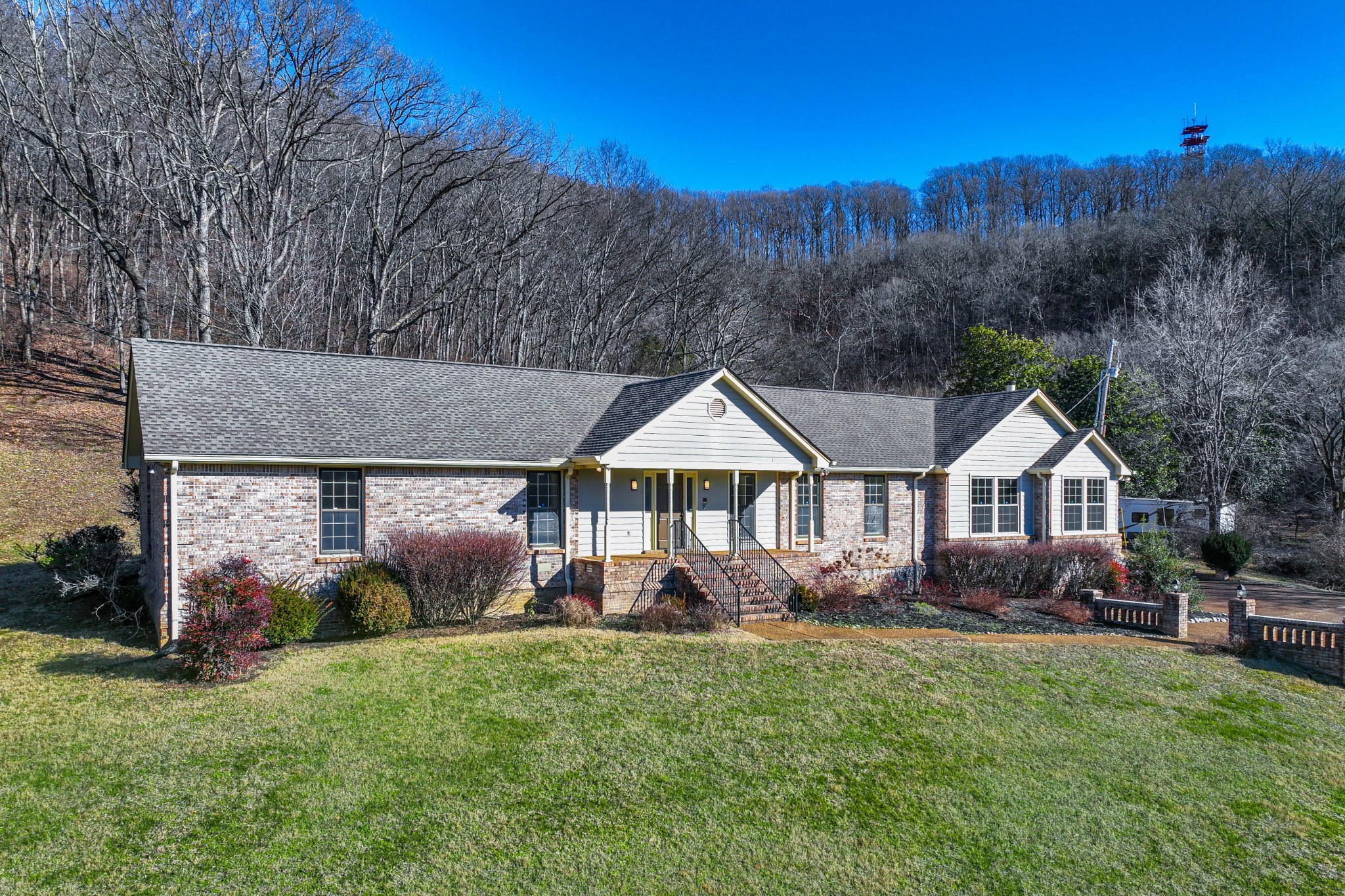 1002 Holly Tree Gap Road Brentwood, TN 37027 - Photo 1 of 27 a view of a house with a big yard and large trees