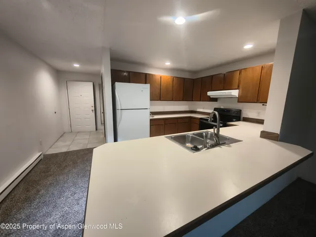 a kitchen with a sink a refrigerator and cabinets