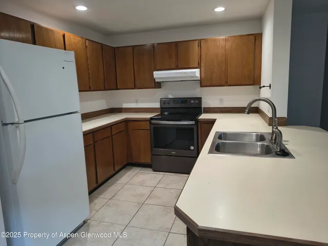 a kitchen with a refrigerator sink and cabinets