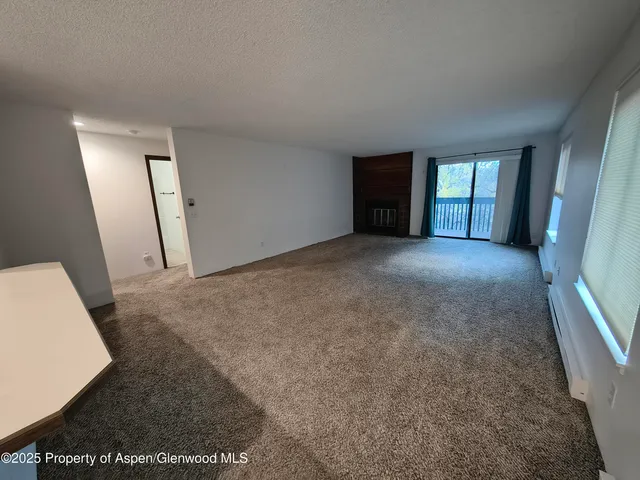 an empty room with windows and bathroom