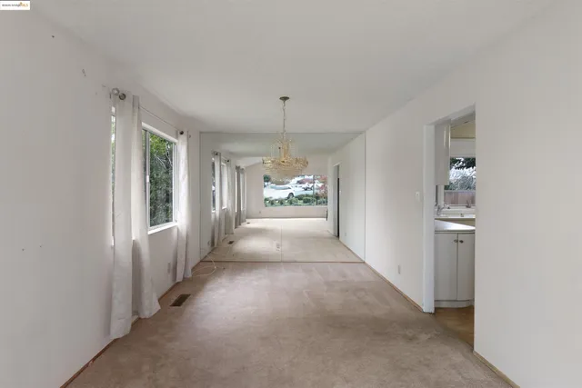 a view of a hallway with a glass door and furniture