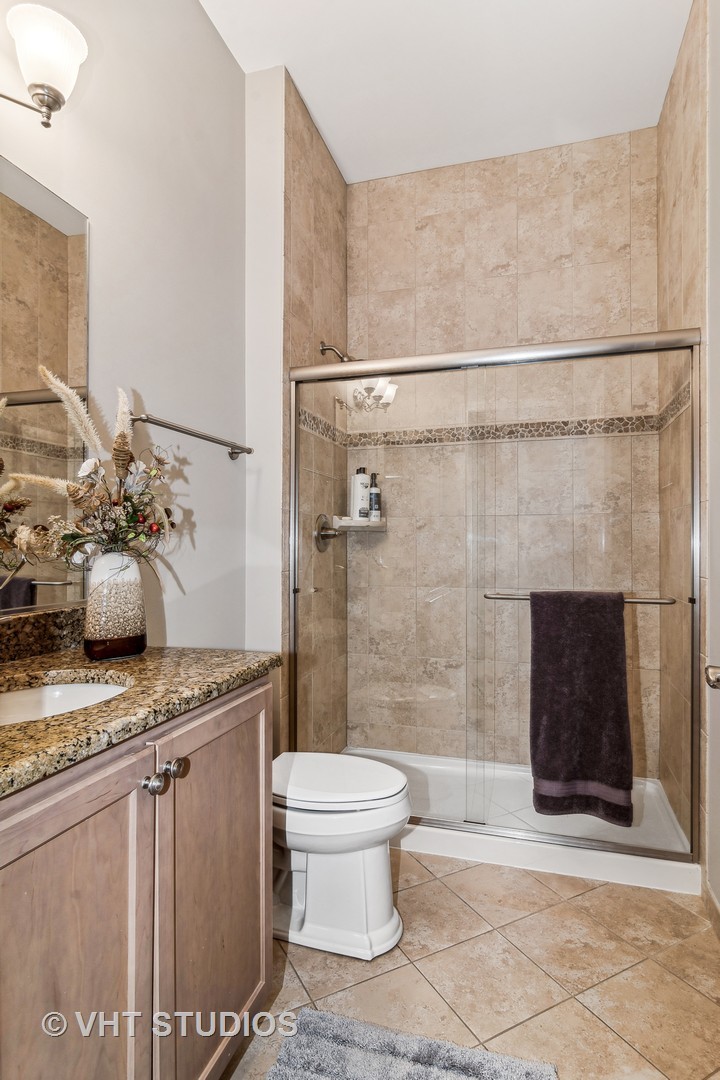 3870 Eagle Ridge Drive Elgin, IL 60124 - Photo 16 of 20 a bathroom with a granite countertop sink a toilet and shower