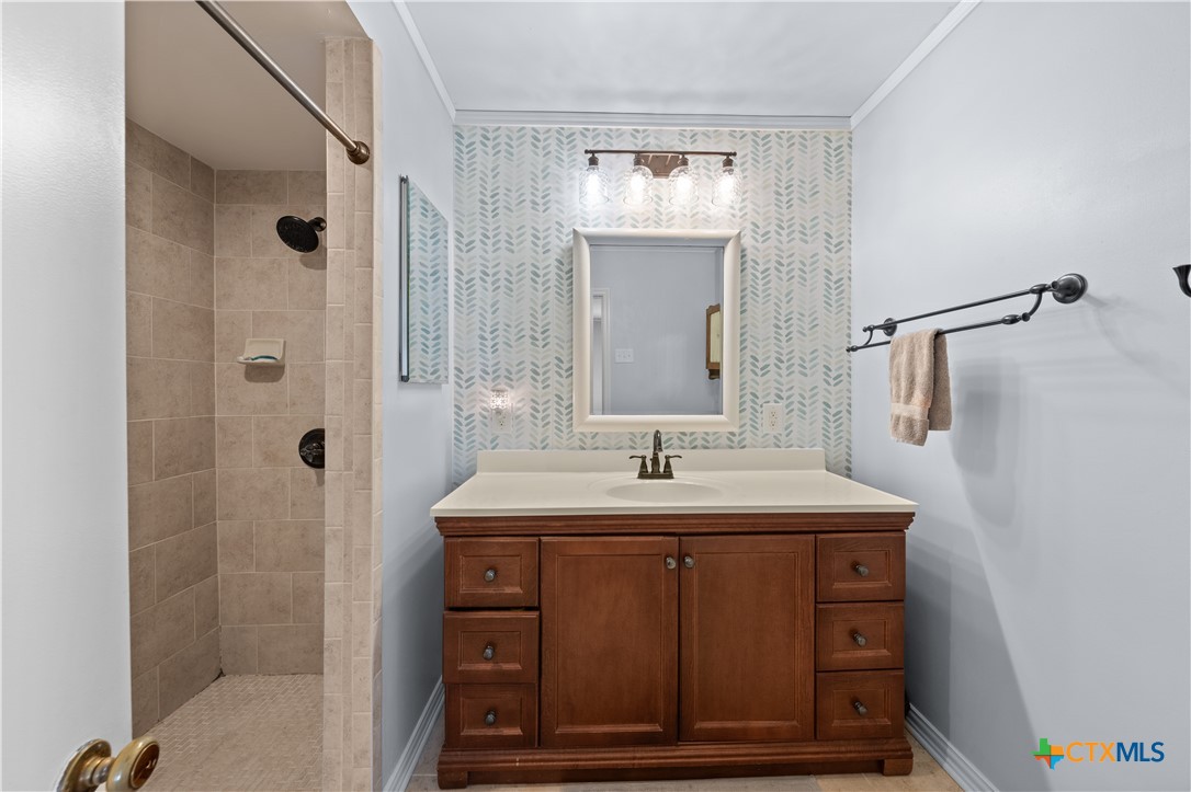 1902 North 7th Street Temple, TX 76501 - Photo 16 of 33 a bathroom with a sink a mirror and shower