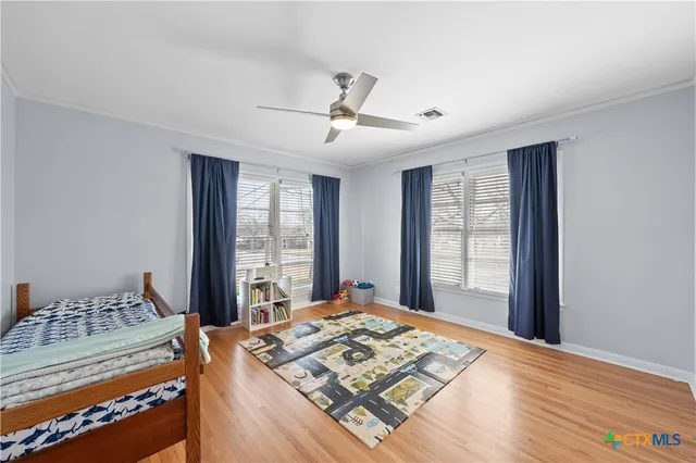 a bed sitting in a spacious bedroom next to a window