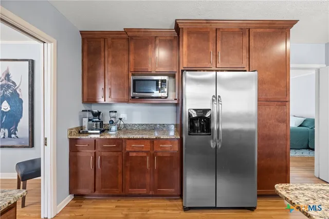 a modern kitchen with granite countertop stainless steel appliances and refrigerator