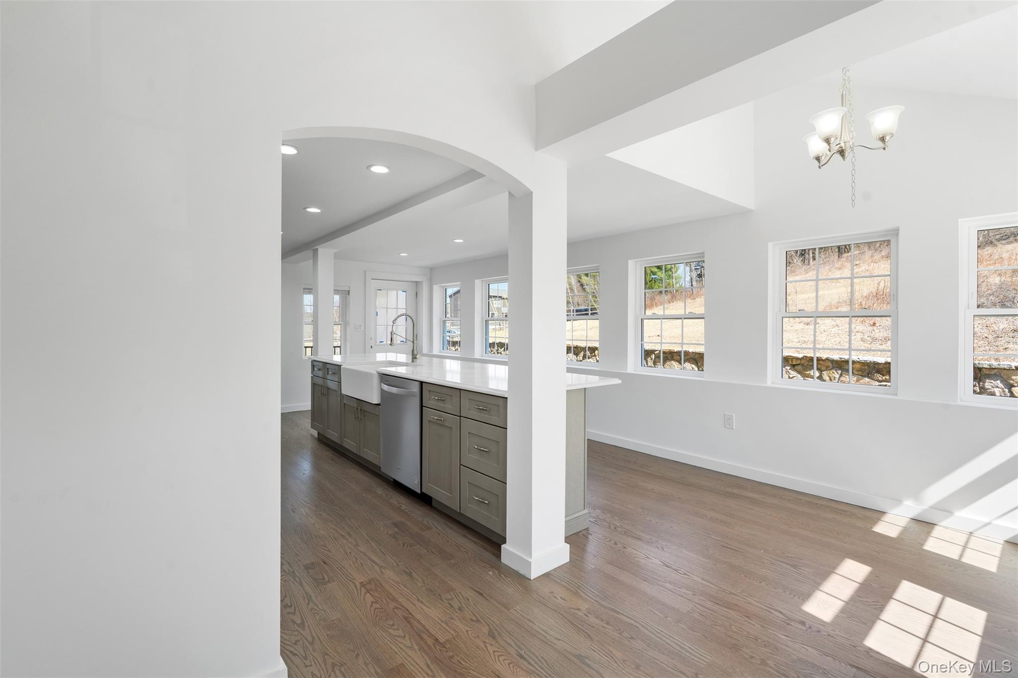 70 Barmore Road LaGrangeville, NY 12540 - Photo 10 of 47 Kitchen featuring gray cabinetry, arched walkways, dark wood-style flooring, stainless steel dishwasher, and light countertops