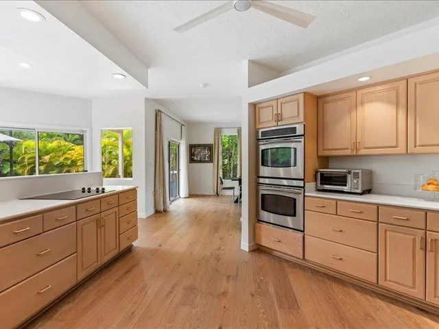 a large kitchen with stainless steel appliances granite countertop a stove and a refrigerator