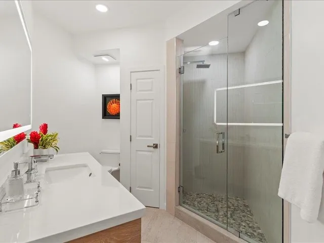 a bathroom with a sink vanity and shower