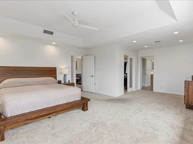 a spacious bedroom with a bed and a lamp