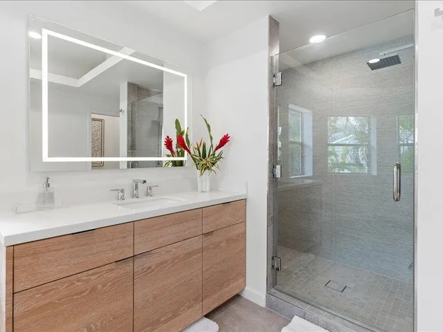 a bathroom with a shower sink and mirror