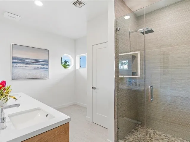 a bathroom with a shower sink and mirror