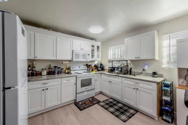 a kitchen with cabinets appliances a sink and a window