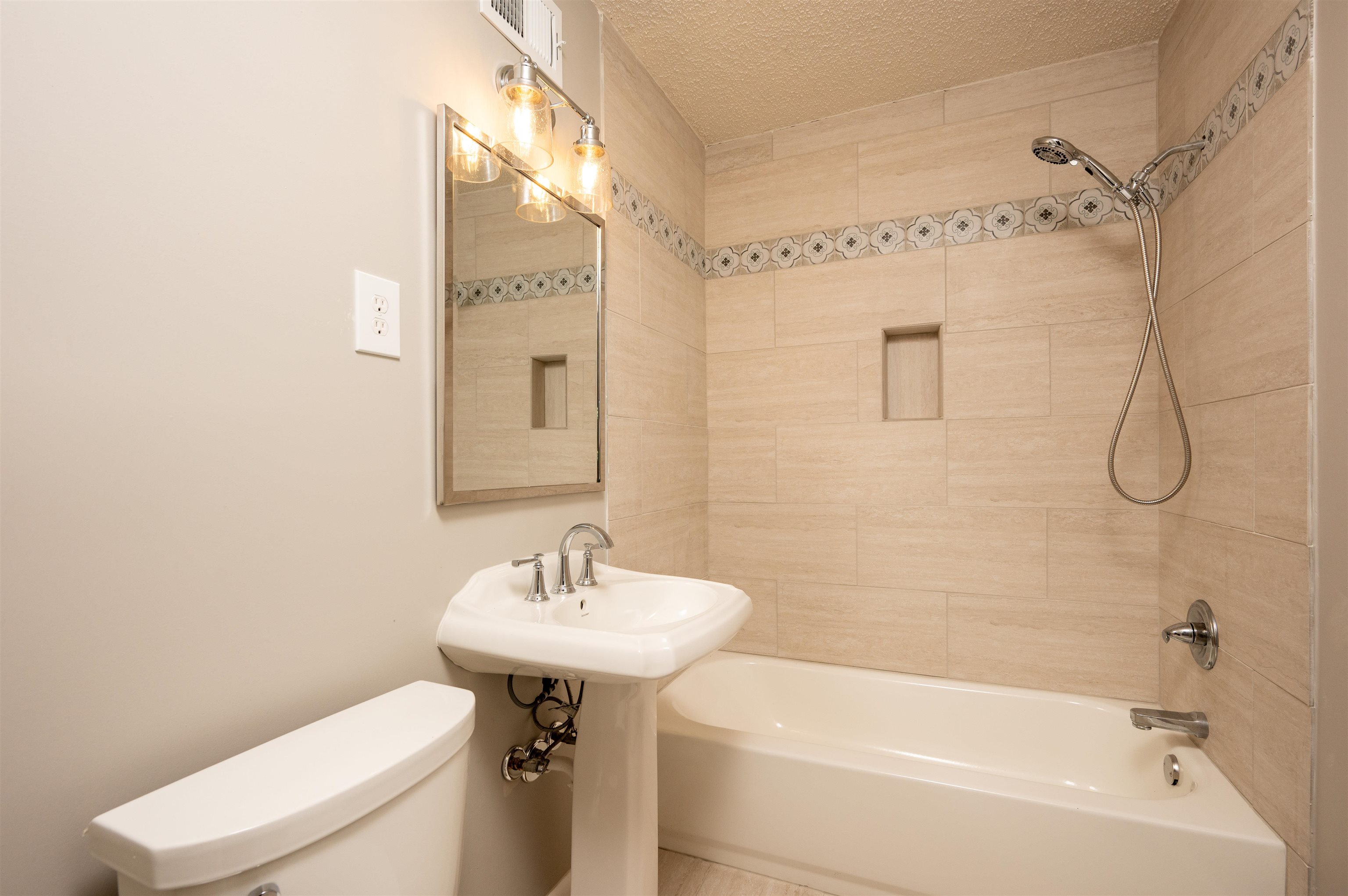 5189 Sea Isle Road Memphis, TN 38117 - Photo 9 of 16 Bathroom featuring tiled shower / bath combo, toilet, and a textured ceiling. newly renovated.