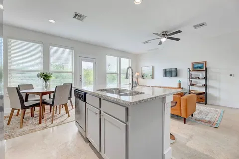 a dining hall with stainless steel appliances granite countertop furniture and a large window
