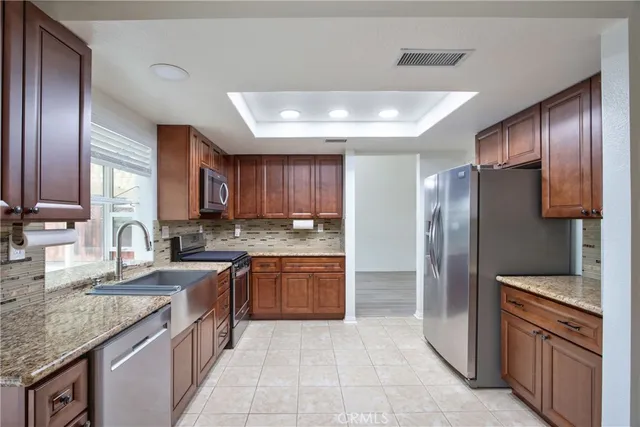 a kitchen with stainless steel appliances granite countertop a sink stove and refrigerator