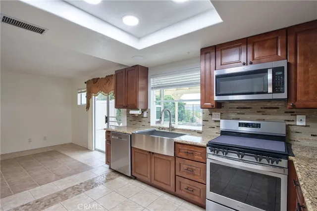 a kitchen with stainless steel appliances granite countertop a stove a sink and a microwave