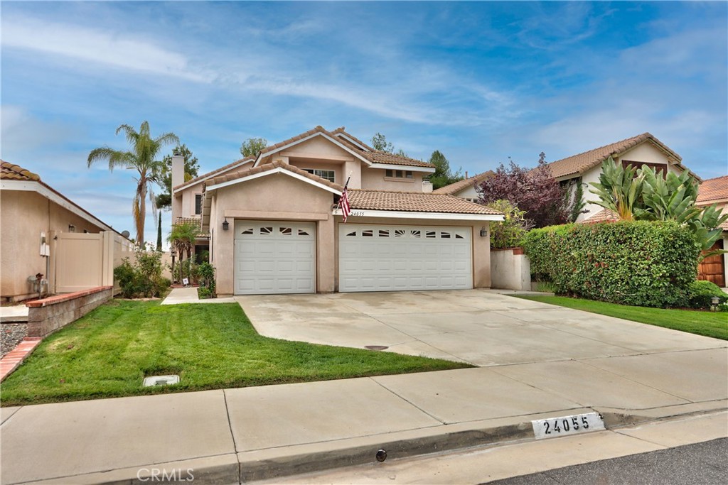 24055 Golden Pheasant Lane Murrieta, CA 92562 - Photo 2 of 38 a front view of a house with a yard and garage