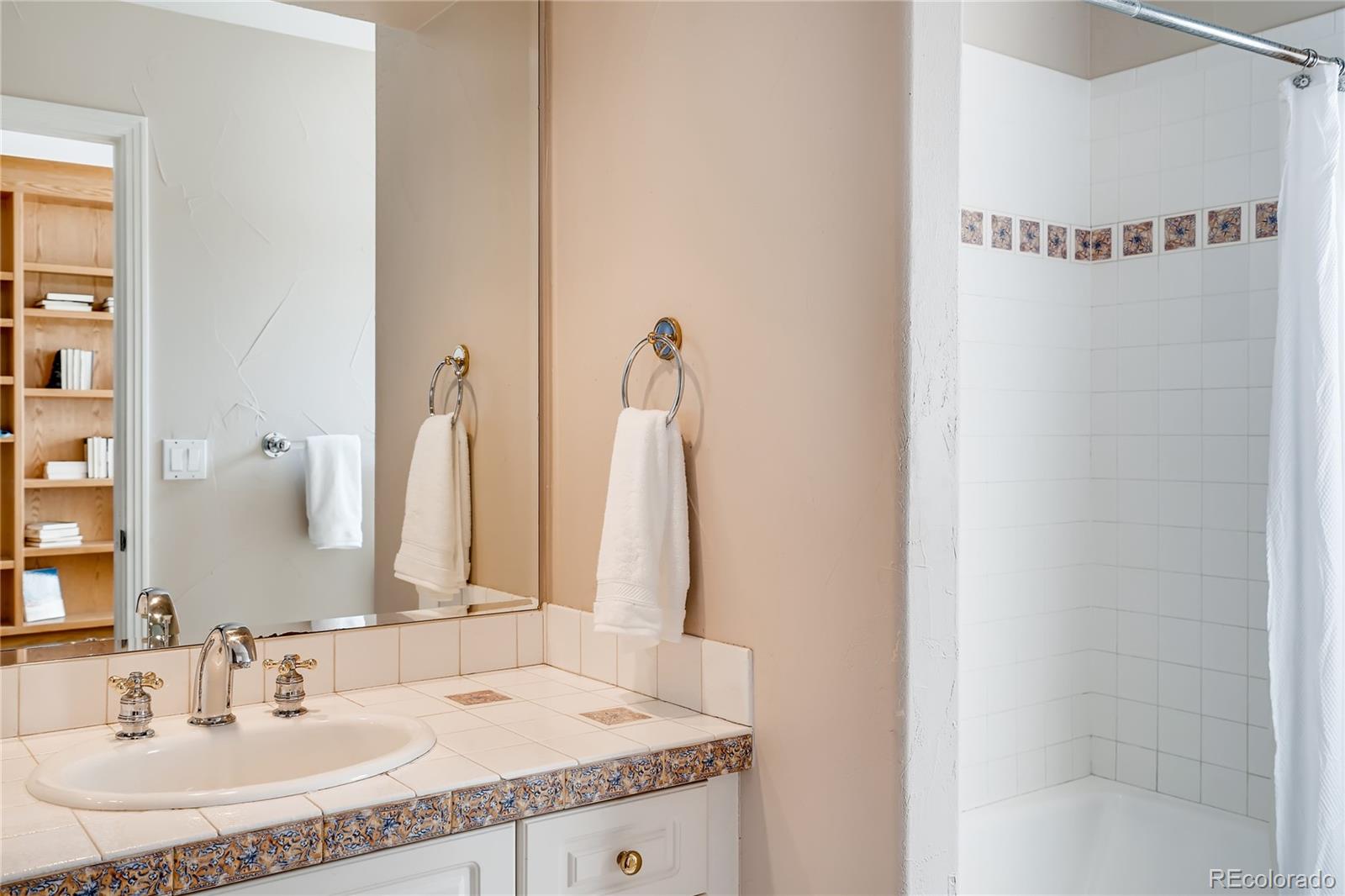 8618 Colonial Drive Lone Tree, CO 80124 - Photo 17 of 39 a bathroom with a granite countertop sink and a mirror