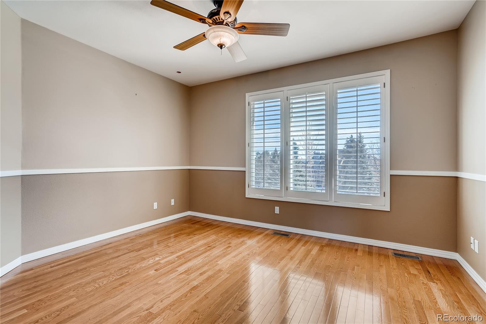 8618 Colonial Drive Lone Tree, CO 80124 - Photo 24 of 39 a view of an empty room with a window and wooden floor