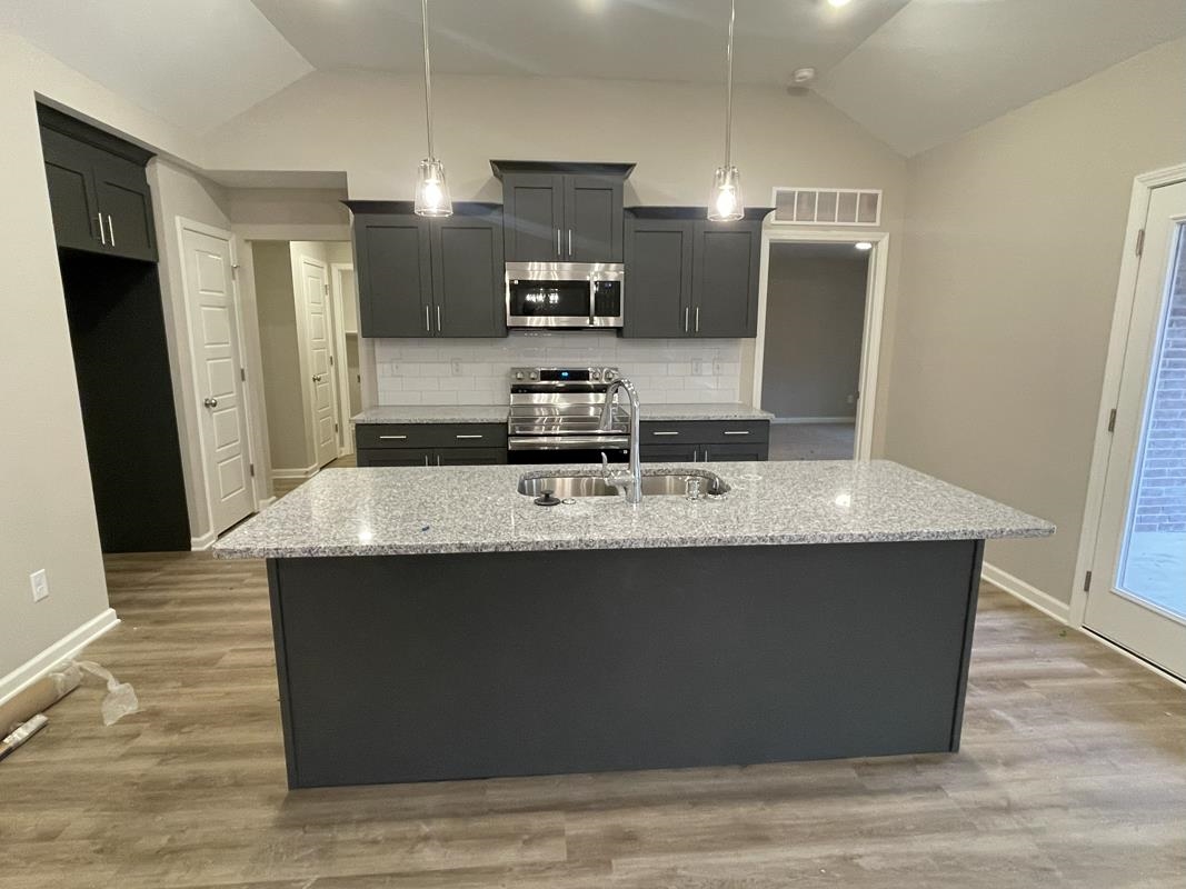 102 Stone Brook Cove Ripley, TN 38063 - Photo 2 of 19 a kitchen with kitchen island stainless steel appliances a sink and refrigerator