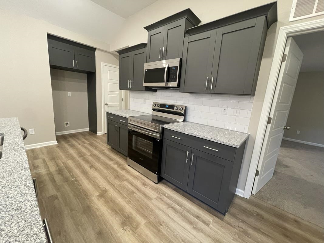 102 Stone Brook Cove Ripley, TN 38063 - Photo 3 of 19 a kitchen with stainless steel appliances granite countertop a stove a sink and a refrigerator