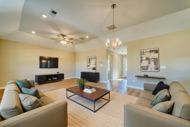 a living room with furniture a chandelier and a couch
