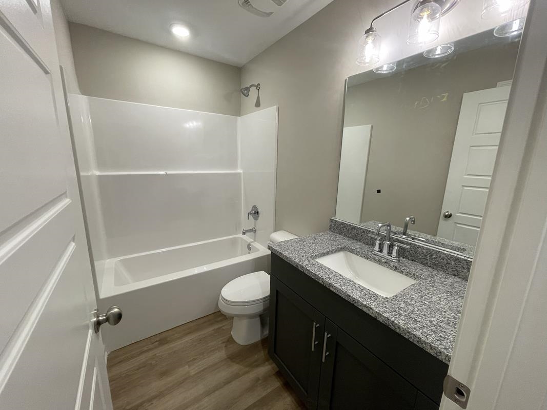102 Stone Brook Cove Ripley, TN 38063 - Photo 7 of 19 a bathroom with a granite countertop sink toilet mirror and bathtub