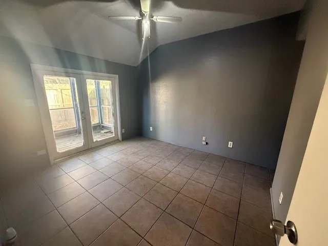 en empty room with windows and chandelier fan