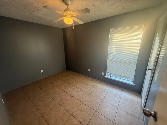 an empty room with windows and fan