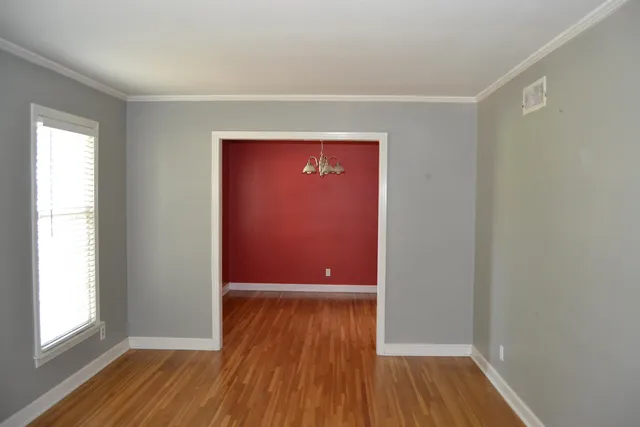 a view of a hallway with wooden floor and a window