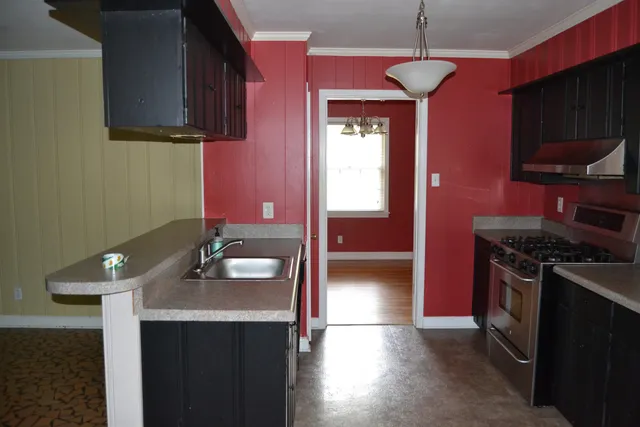 a kitchen with a sink stove top oven and cabinets