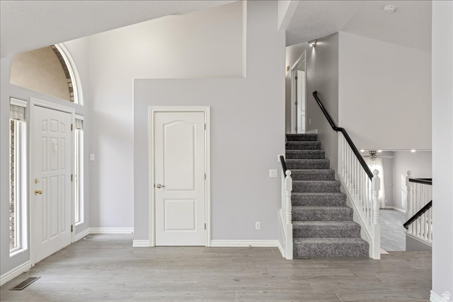 7 Reflection Way St. George, UT 84770 - Photo 9 of 54 Entrance foyer with high vaulted ceiling, light wood-type flooring, and stairs