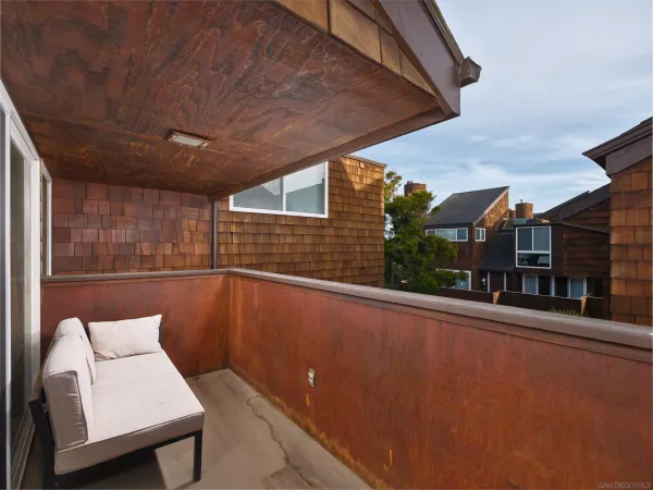 a view of a balcony with two chair and a potted plant